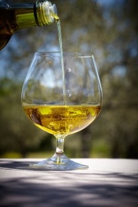 Vue de détail d'une huile d'olive versée dans un verre à pied de dégustation
